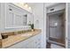 Well-lit bathroom with vanity, granite countertop, and a tiled walk-in shower at 610 Island Way # 302, Clearwater Beach, FL 33767