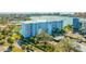 Condo building exterior featuring a parking lot and tropical landscaping at 610 Island Way # 302, Clearwater Beach, FL 33767