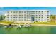 Waterfront condo building featuring boat docks, green space, and community pool at 610 Island Way # 302, Clearwater Beach, FL 33767