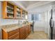 Kitchenette features granite counters, wood cabinets, and stainless steel refrigerator at 610 Island Way # 302, Clearwater Beach, FL 33767