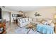 Cozy living room with a large sectional, glass coffee table, and view into the dining area at 610 Island Way # 302, Clearwater Beach, FL 33767