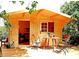 Cozy wooden cabin with an outdoor sitting area and a well-maintained deck under the shade of leafy trees at 7006 41St E Ave, Bradenton, FL 34208