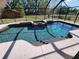 Beautiful screened-in pool with crystal blue water and an attached spa and lovely green yard at 7006 41St E Ave, Bradenton, FL 34208