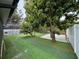 View of large backyard with mature trees and a lush lawn with an updated turf at 7608 Lakeside Blvd, Tampa, FL 33614