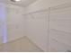 Empty walk-in closet with wire shelving and carpeted floors, ready to be organized at 7882 Sailboat Key S Blvd # 401, South Pasadena, FL 33707