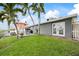 Backyard features a manicured lawn, patio, outdoor dining, and mature palm trees at 7912 3Rd S Ave, St Petersburg, FL 33707