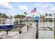 Private dock featuring a boat lift, a dining table under an umbrella, and an American flag at 7912 3Rd S Ave, St Petersburg, FL 33707
