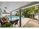 Outdoor patio features lounge chairs, a table, a lush landscape, and pool at 7912 3Rd S Ave, St Petersburg, FL 33707