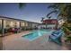 A backyard featuring a sparkling pool, surrounded by tropical landscaping and comfortable seating at 7912 3Rd S Ave, St Petersburg, FL 33707