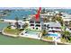 Aerial view of a stunning three-story home with a pool, spa, and waterfront access at 882 Bay Point Dr, Madeira Beach, FL 33708