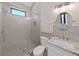 Well-lit bathroom featuring a glass enclosed shower, toilet, and vanity at 882 Bay Point Dr, Madeira Beach, FL 33708