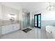 Bright bathroom with double vanities, glass shower, and soaking tub at 882 Bay Point Dr, Madeira Beach, FL 33708