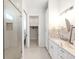 Well-lit bathroom featuring a glass enclosed shower, ample cabinet space, and a walk-in closet at 882 Bay Point Dr, Madeira Beach, FL 33708