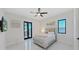 Bedroom with a ceiling fan, tv, balcony access, and a comfortable bed at 882 Bay Point Dr, Madeira Beach, FL 33708