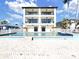 Beautiful exterior view of a luxurious three-story home with a pool and waterfront views at 882 Bay Point Dr, Madeira Beach, FL 33708
