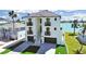 Stunning three-story waterfront home with modern architectural details, multiple balconies and a paved driveway at 882 Bay Point Dr, Madeira Beach, FL 33708