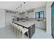 Open concept kitchen with stainless steel appliances, large island with seating and views to the living and dining area at 882 Bay Point Dr, Madeira Beach, FL 33708