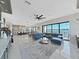 Bright living room featuring an open floor plan, sleek blue sectional, and breathtaking water views at 882 Bay Point Dr, Madeira Beach, FL 33708