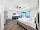 Bright bedroom featuring water views and a tray ceiling with a ceiling fan at 882 Bay Point Dr, Madeira Beach, FL 33708