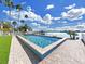 Stunning backyard with a rectangular pool, turf lawn, and direct access to the tranquil waterfront at 882 Bay Point Dr, Madeira Beach, FL 33708