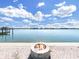Beautiful water view with a fire pit in the foreground and a dock on the left side of the frame at 882 Bay Point Dr, Madeira Beach, FL 33708