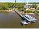 Aerial view showcasing a private dock with boat lift, waterfront access, and lush green surroundings at 8820 S Hickory Ln, Riverview, FL 33578