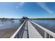 Long wooden dock extending into the calm water, leading to a covered structure with scenic views at 8820 S Hickory Ln, Riverview, FL 33578