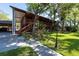 Two-story home with a covered porch surrounded by lush greenery and a well-manicured lawn at 8820 S Hickory Ln, Riverview, FL 33578