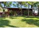 Lush green lawn and trees surround this 2-story home, which boasts a large covered porch at 8820 S Hickory Ln, Riverview, FL 33578