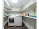Well-lit laundry room with modern washer and dryer and convenient built-in shelving for storage at 8820 S Hickory Ln, Riverview, FL 33578