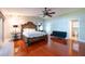 Bright main bedroom with hardwood floors, a large bed, and an ensuite bathroom at 8820 S Hickory Ln, Riverview, FL 33578