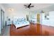 Bright main bedroom with wood floors, a ceiling fan, and a view to the main bathroom at 8820 S Hickory Ln, Riverview, FL 33578