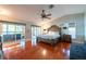 Main bedroom with hardwood floors, a large bed, access to a balcony, and an ensuite bathroom at 8820 S Hickory Ln, Riverview, FL 33578