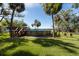 Backyard pool overlooking the water with a wooden deck and beautiful landscaping at 8820 S Hickory Ln, Riverview, FL 33578