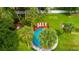 Aerial view of a backyard oasis featuring a pool, palm trees, and deck with lounge chairs at 8820 S Hickory Ln, Riverview, FL 33578