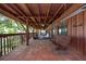 Expansive porch with tile floor, wooden beams, and a swing for enjoying the outdoors at 8820 S Hickory Ln, Riverview, FL 33578