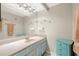 Bright bathroom featuring a vanity with a large mirror and a charming blue cabinet at 9415 Blind Pass Rd # 704, St Pete Beach, FL 33706