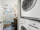 Modern bathroom with a glass shower, updated vanity, and convenient stacked washer and dryer at 9415 Blind Pass Rd # 704, St Pete Beach, FL 33706
