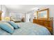 Inviting bedroom featuring a comfortable bed, dresser, and spacious mirrored closet doors at 9415 Blind Pass Rd # 704, St Pete Beach, FL 33706
