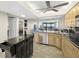 Bright, modern kitchen with stainless steel appliances, an island, and a washer/dryer behind a sliding door at 9415 Blind Pass Rd # 704, St Pete Beach, FL 33706