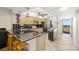 Open kitchen featuring modern appliances, dark countertops, and ample cabinet space, adjacent to balcony access at 9415 Blind Pass Rd # 704, St Pete Beach, FL 33706