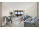 Bright living room featuring comfortable seating, a TV, and access to a balcony with great views at 9415 Blind Pass Rd # 704, St Pete Beach, FL 33706