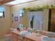 Well-lit bathroom with a dual sink vanity, floral accents, and a shower/tub combination, offering a comfortable space at 7006 41St E Ave, Bradenton, FL 34208