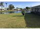 Waterside backyard featuring a green lawn with view of canal and neighboring houses at 1002 Pussywillow Ln, Bradenton, FL 34208