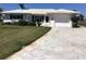 Charming single-story home featuring a well-manicured lawn and a patterned concrete driveway at 1002 Pussywillow Ln, Bradenton, FL 34208