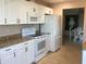 Bright kitchen featuring white appliances, tile flooring, and dining area at 1002 Pussywillow Ln, Bradenton, FL 34208