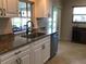 Bright kitchen with granite counters, stainless steel dishwasher, and tile flooring at 1002 Pussywillow Ln, Bradenton, FL 34208