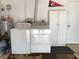 This laundry room features a full size washer, dryer, and cabinet for storage at 1002 Pussywillow Ln, Bradenton, FL 34208