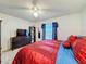 Bedroom featuring a ceiling fan, dresser with TV, and sliding glass doors with curtains at 1102 Springtime Dr, Holiday, FL 34691
