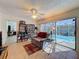 Bright living area with tile floors and sliding doors opening to an outdoor pool area at 1102 Springtime Dr, Holiday, FL 34691